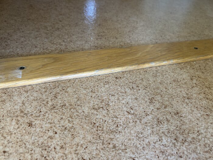 Linoleumgolv i barnrum med trätröskel och synliga skruvar, tagen i diskussion om att byta golv, flerfamiljshus från 80-talet.