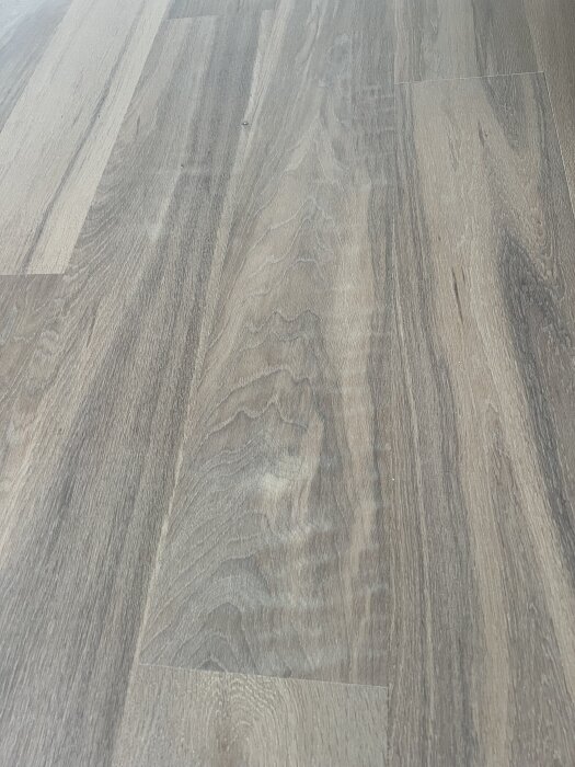 Slipat ekgolv med flammig yta och små repor.