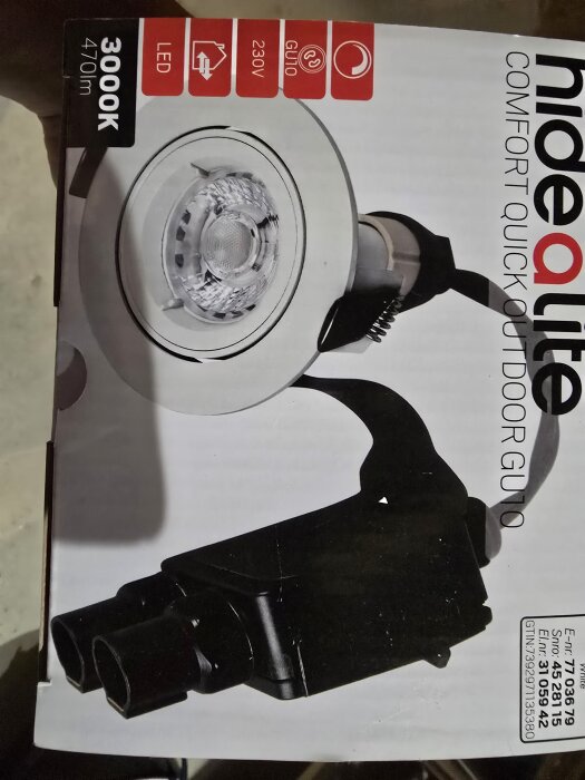 Förpackningen av en Hide-a-lite utomhusspotlight med GU10 LED-lampa, 230V och dimmerfunktion, visas på bilden.