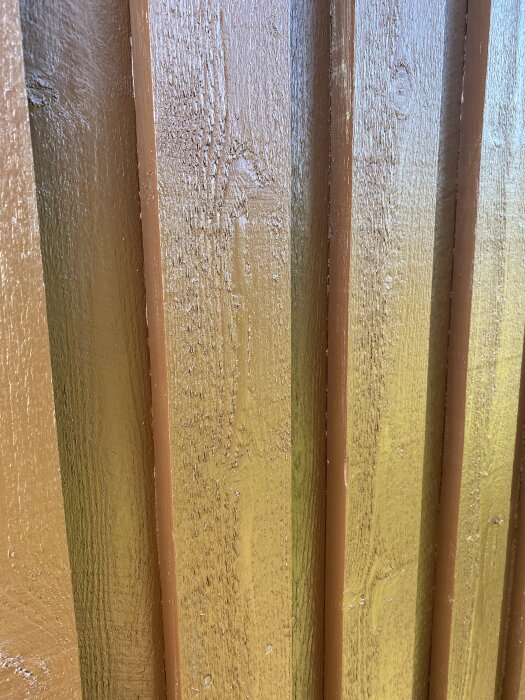 En närbild av bruna träpaneler med strukturerad yta, potentiellt från ett byggprojekt med 70-talsstil.