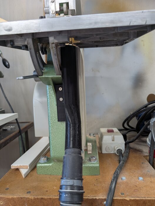 Begagnad bandsåg med ett nytt 3D-utskrivet dammsugarmunstycke monterat under, fäst med M4-skruvar för att minimera damm.