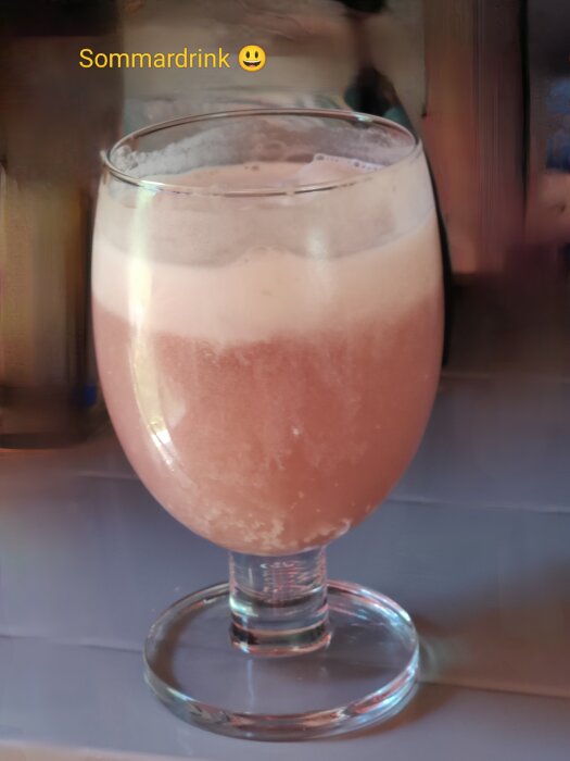 Svalkande sommardrink i ett glas med skum på toppen, perfekt för varma dagar.
