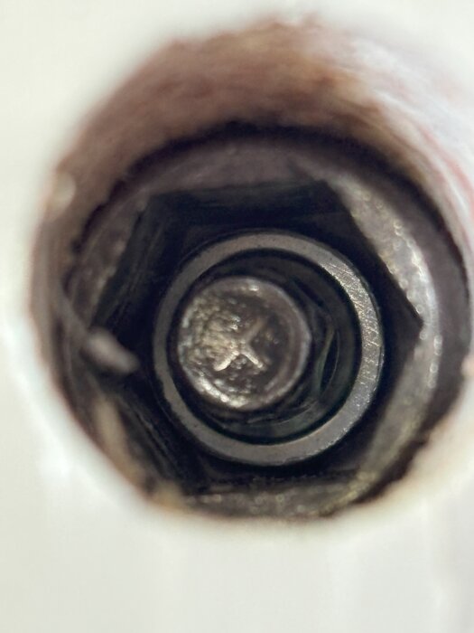 Närbild på en karmskruv med sexkantigt huvud och en insexnyckelinsats.