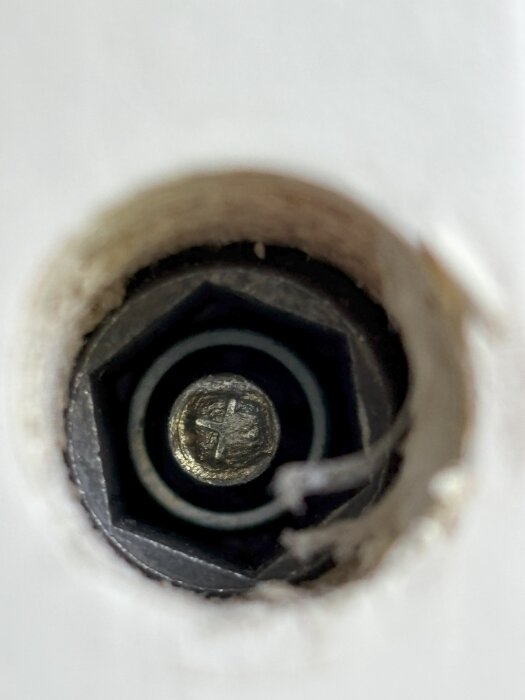 Närbild av en karmskruv inuti en dörrkarm.