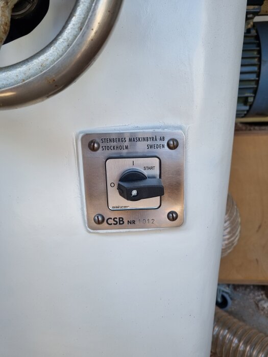 Strömbrytare på en maskin med texten "STENBERGS MASKINBYRÅ AB STOCKHOLM SWEDEN".