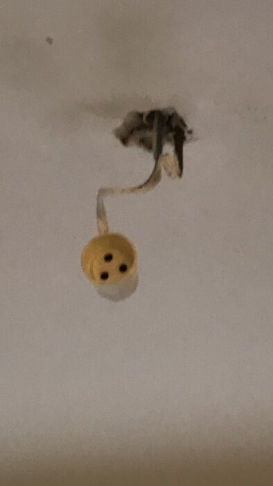 Ojordad lamppropp hänger från taket i en lägenhet.