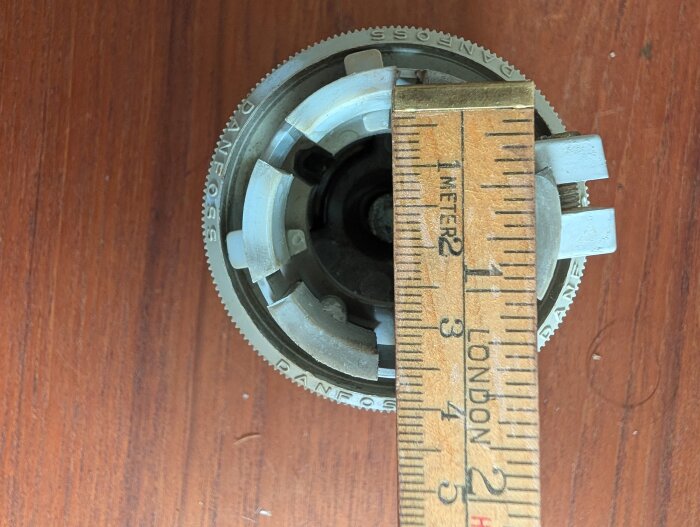 Termostat från Danfoss mätt med linjal, mått cirka 3 cm, på träbord.