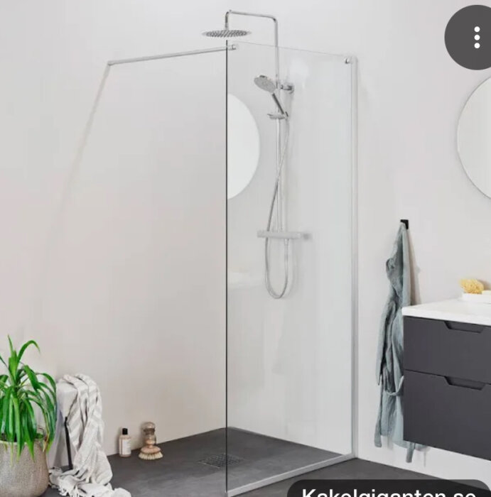 Duschhörna med glasvägg, regndusch och väggmonterad duschstång.