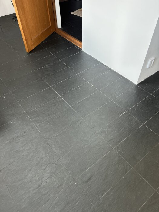 Kluven lerskiffer på hallgolvet med synliga dörrkarmar.