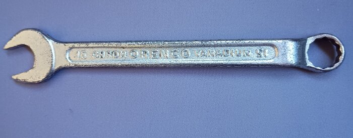 Kromad ringnyckel av märket Orenco på lila bakgrund, synlig text visar storlek "15" och material "Chrom Vanadium".