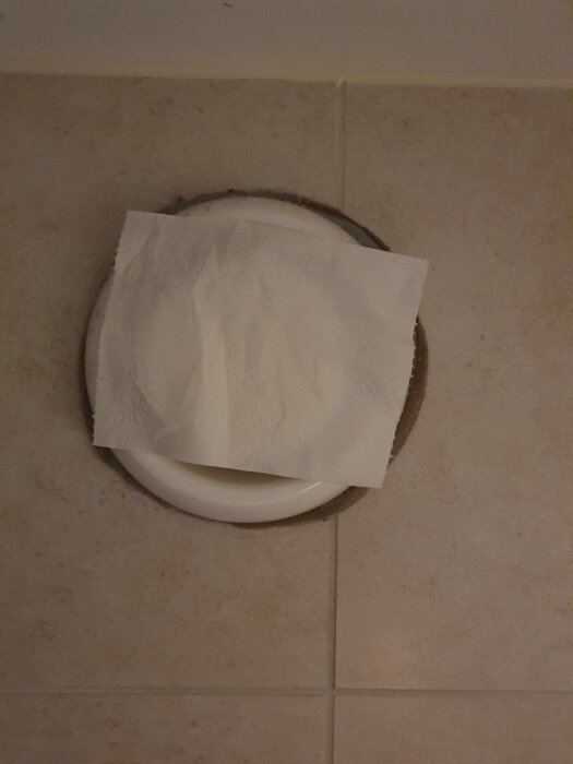 Ventilationsöppning med papper fastsatt över i kökskakel.