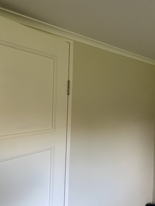 Dörrkarm i beige vägg, renoverad källare med nyputsade väggar och lagade lättbetongväggar.