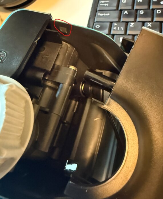 Närbild av en Gardena-enhets inre del med en markerad clipsdel, bredvid ett tangentbord.