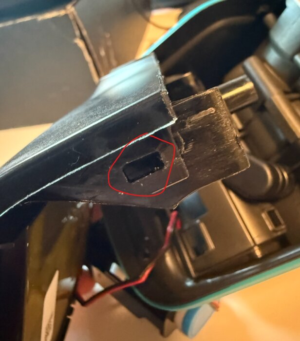 Närbild av en Gardena-enhet där en del av plastkonstruktionen med clips är markerad i rött för demontering.