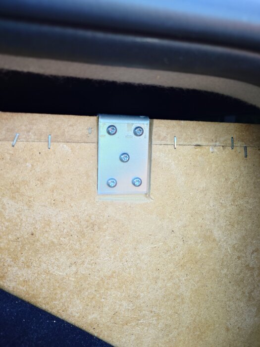 Vinkelfäste förstärker baslådans träskiva med flera skruvar, del av ett byggprojekt för att stabilisera grabben baslåda i epan.