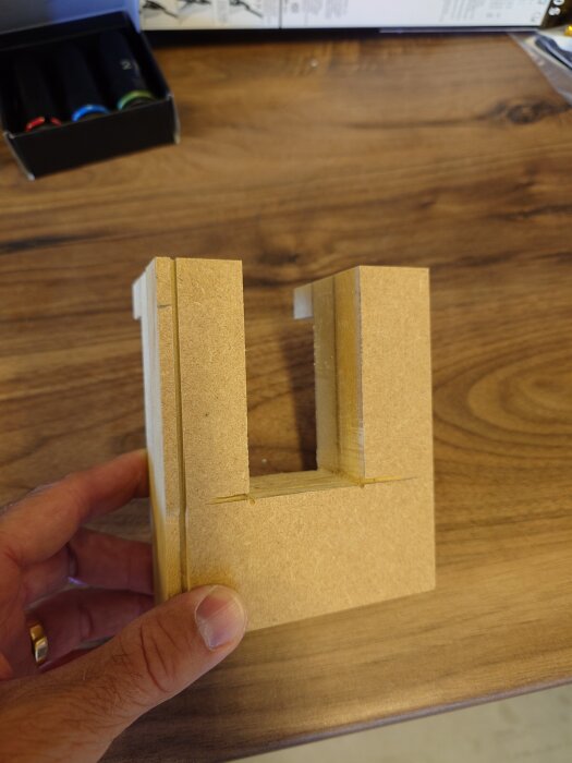 Fräsmall för försänkning av vinkeljärn visas på träbord. Observera detaljerad snidning och rundade kanter.