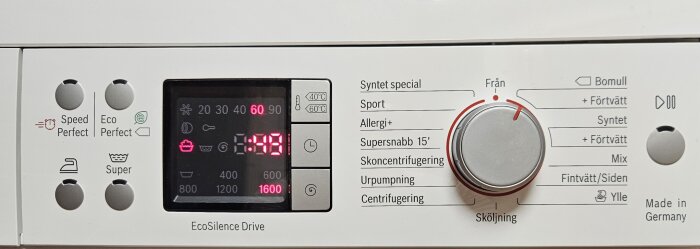 Kontrollpanel på tvättmaskin med inställningar för olika program och temperaturer, display visar återstående tid 1:58.
