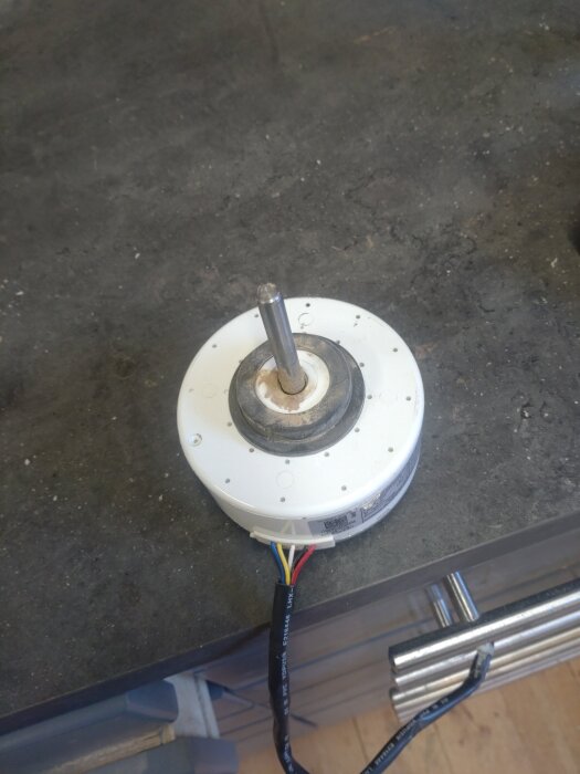 Lagerbyte på luftvärmepumpens innerdel, placerad på arbetsbänk i snickarverkstad.