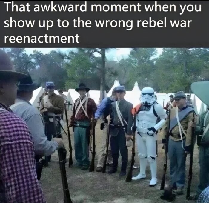 Grupp människor i historiska militärkläder vid ett reenactment, med en person i en stormtrooper-dräkt från Star Wars, omgiven av tält och träd.