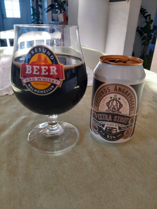 Glas med mörk stout och en burk från Öresunds Ångbryggeri på ett bord.
