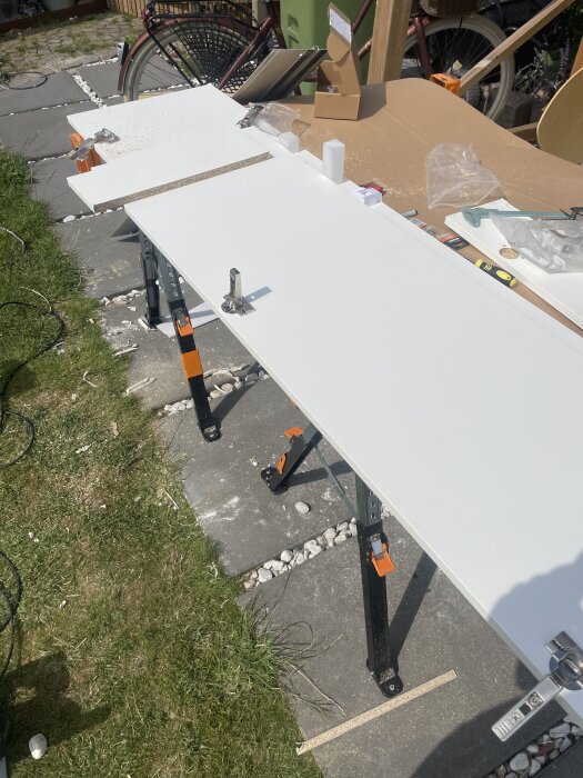 Ikealuckor under bearbetning utomhus på arbetsbänk med borrar och verktyg, en cykel syns i bakgrunden.