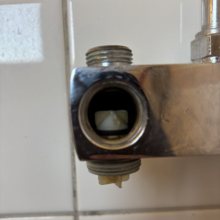 FM Mattsson-duschblandare med delvis synlig omkastarkolv som fastnat och behöver bytas ut; bilden visar insidan av blandarens öppning.