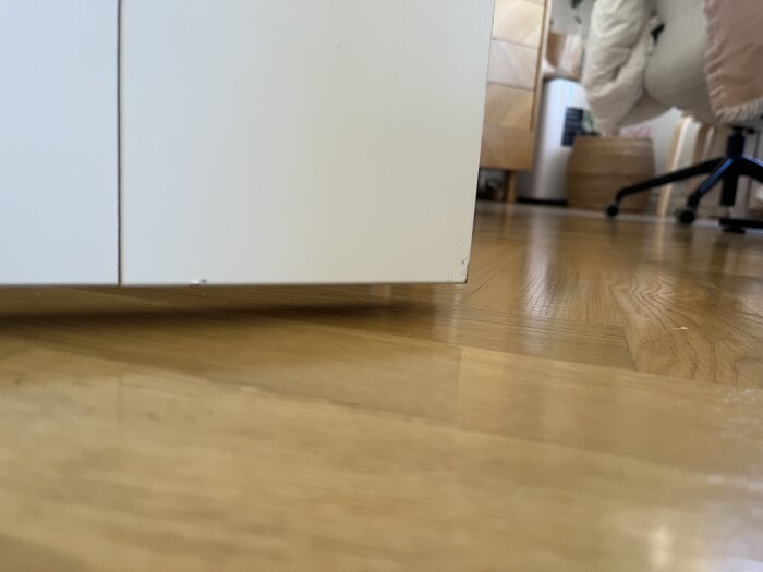 Skjutdörr med glipa mot golvet i en lägenhet, visar brist på skena under och problem med ljudisolering.