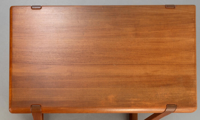 Teakbordskiva med mörka stråk synliga på ytan.