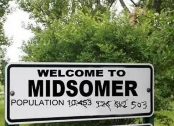 Vägskylt som välkomnar till Midsomer där befolkningsantalet är överstruket flera gånger och nu står som 503 mot en grönskande bakgrund.