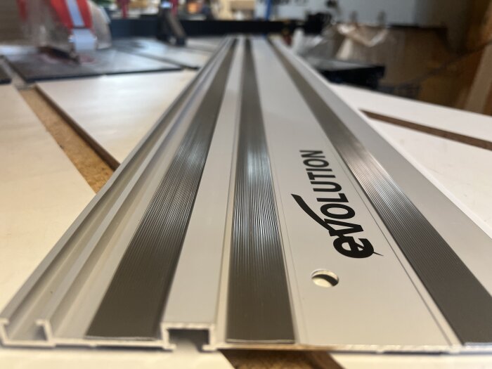 Metallskena med texten "EVOLUTION" i närbild, som förmodas passa verktyg från Makita och Festool.