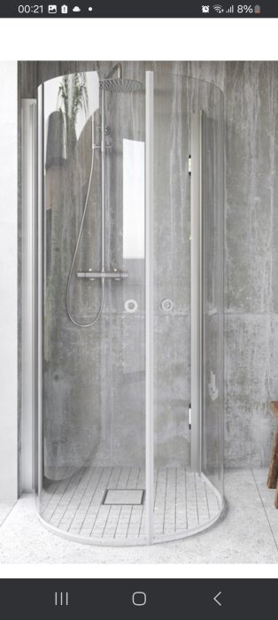 Rund duschkabin med glasväggar och grått kakel i bakgrunden, samt en regndusch och trägolv inuti kabinen.