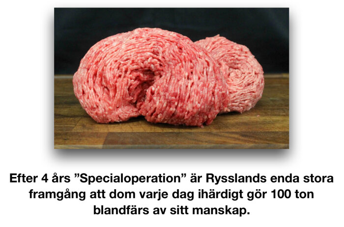 Köttfärs i två högar på en träskärbräda med en svart bakgrund.