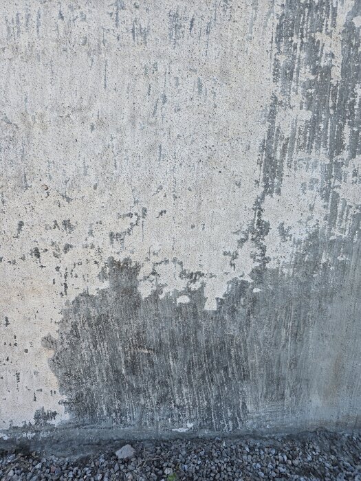 Del av en husgrund från 60-talet med flagnande plastfärg och spår av högtryckstvätt, visar områden där färgen fortfarande sitter kvar.