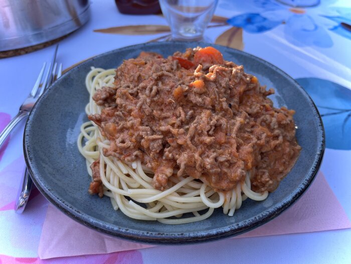 Tallrik med spaghetti och köttfärssås på en balkong, serverad för middag.