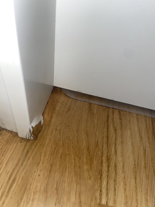 Vattenskada på vit list, färgsläpp i hörnet, påträffad intill träbänkskiva.