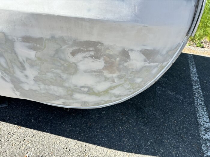 Närbild av sliten och slipad vagn innan målning, ytan är förberedd med spackel och grundad för att bli målad äggskalsvit.