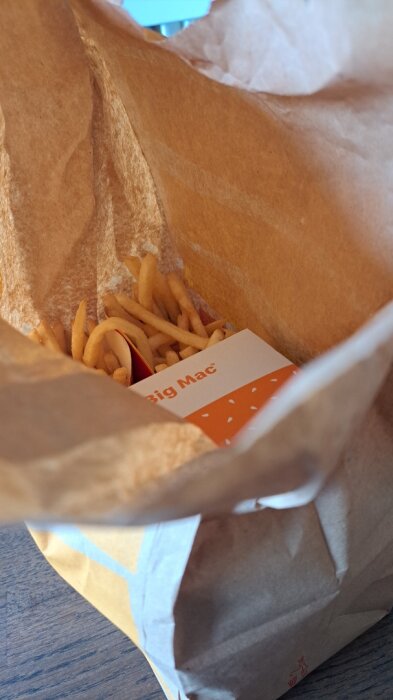 Papperspåse med snabbmat, innehållande pommes frites och en Big Mac-förpackning.