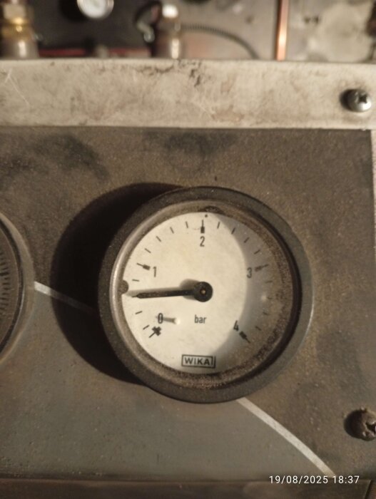 Manometer som visar panntryck på ca 0,6 bar, del av ett ackumulatortanksystem. Datumstämpel synlig längst ner på bilden.