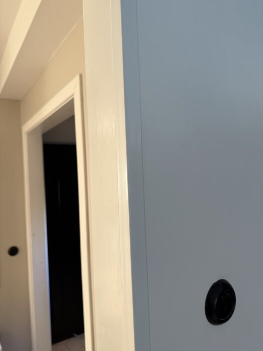 Väggen där ett hål tagits upp för att bygga in ett side-by-side kylskåp; synlig dörröppning i bakgrunden.