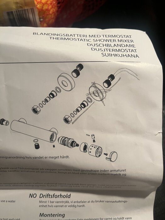 Instruktionsblad för montering av duschblandare med termostat, som visar en sprängskiss av delarna och installationsanvisningar.