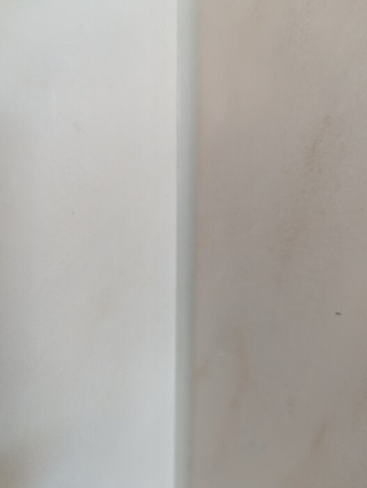 Nära bild av en rinnande linje av silikonfärg på en ljus vägg i badrummet, potentiellt med mögelproblem och missanpassad färg.