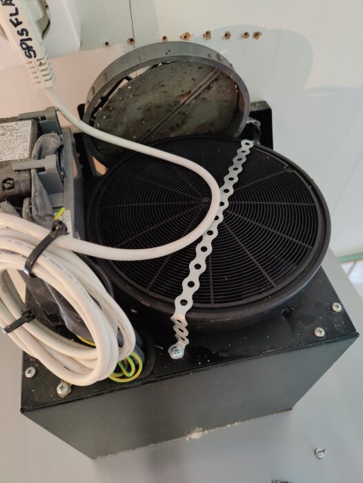 Frånluftsventilationssystem med rör, kablar och en fläkt.