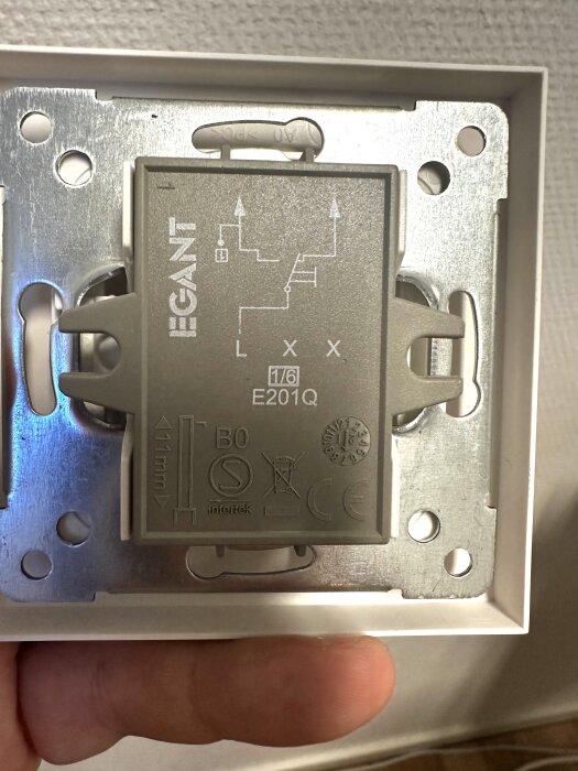 Väggmonterad ljusdimmer med etiketten "EGANT" och modellbeteckning "E201Q" visas, hålls i en hand.