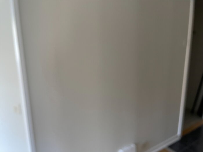 Vägg med bubblor och ojämnheter från undermåligt utförd tapetsering och dåligt underarbete i en lägenhet.