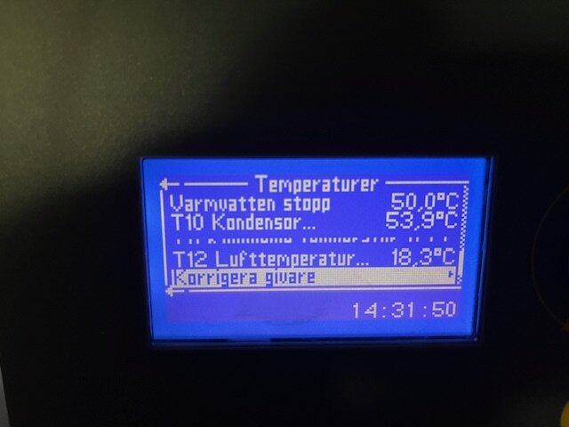 Display på värmepump visar temperaturer: varmvatten 50°C, kondensor 53,9°C, luft 18,3°C, samt tid 14:31:50.