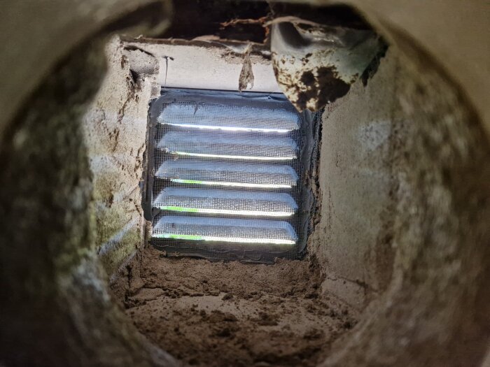 Ventilöppning sedd inifrån med ny bruksyta och galler, innan installation av innerdel och målning.