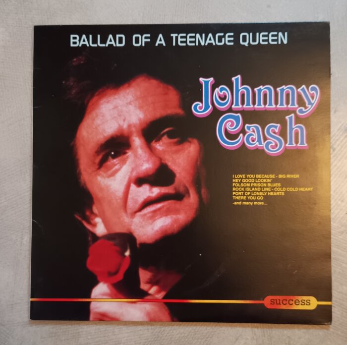 Skivomslag för "Ballad of a Teenage Queen" av Johnny Cash, med artisten hållande en röd ros.