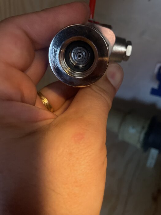 Närbild av en person som håller ett Grohe Blue Professional-munstycke, där tätningen för kolsyran saknas inuti.