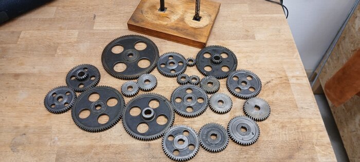 Flera olika storlekar av drev för svarv på ett träbord, vilket kan användas för olika matningar och gängor.