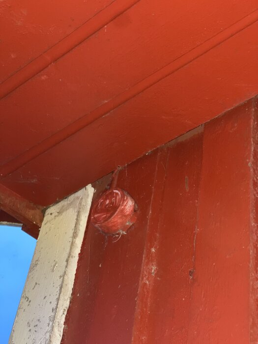 Rött runt objekt på fasaden utanför köket.